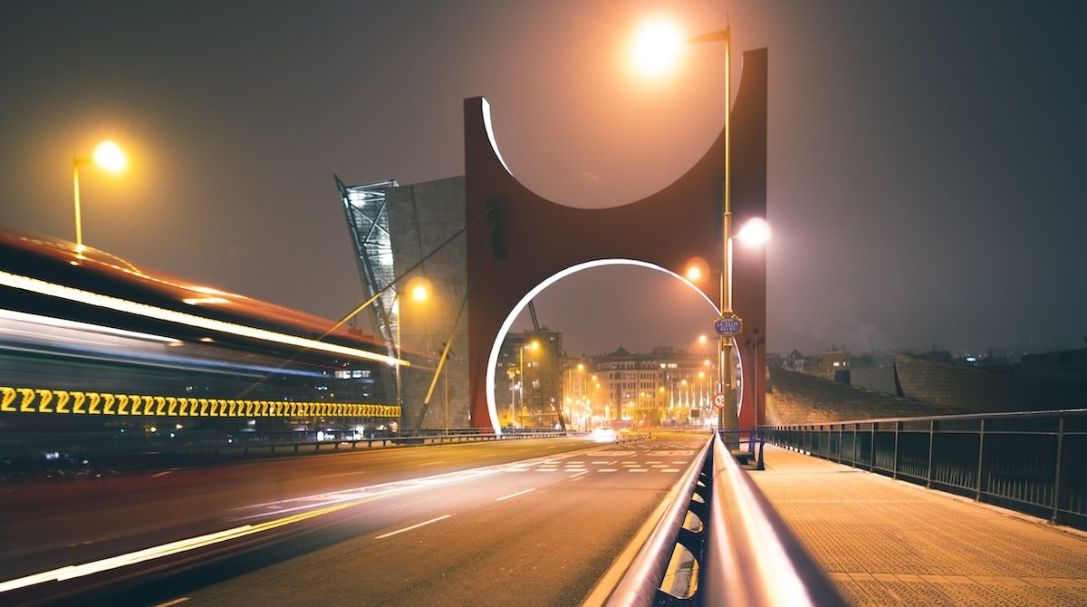 A long shot of La Salve bridge at night with highway lights and unique bridge arc in Bilbao Spain